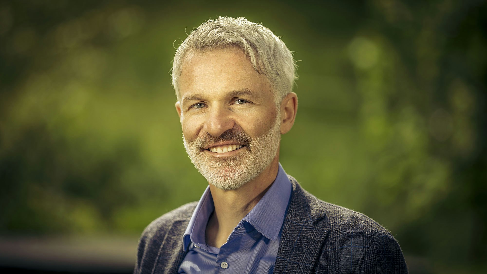 Profile photo of a man with short white hair and trimmed beard.