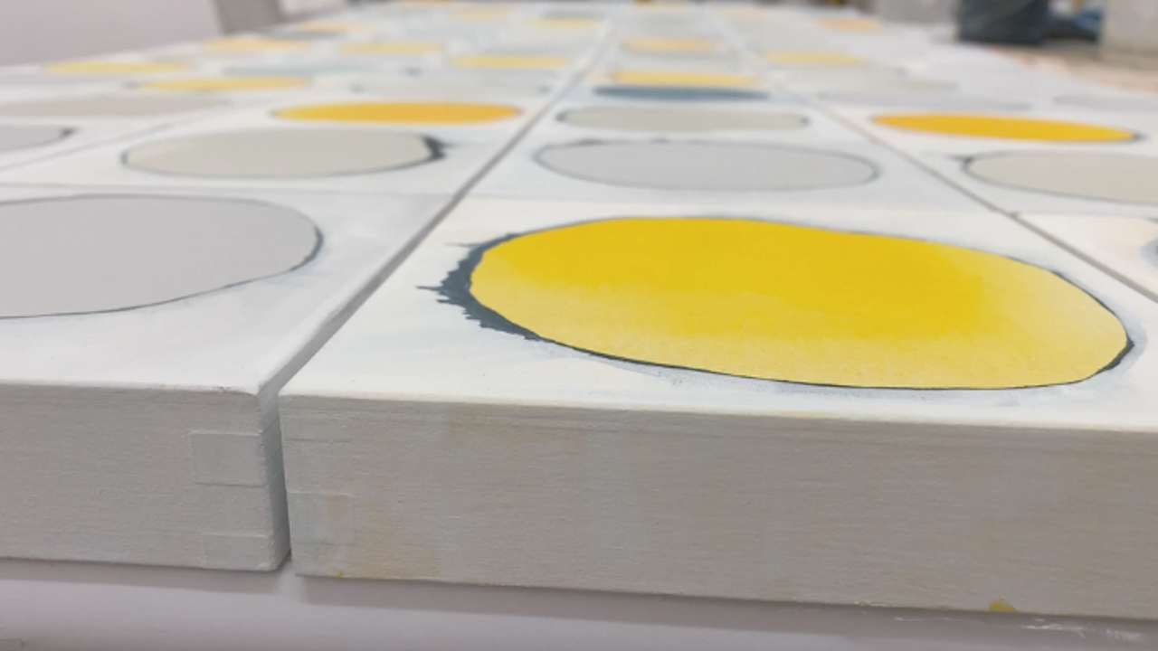 strung works of art with a painted ring filled in a wide variety of colors. Gray, yellow or dark blue.