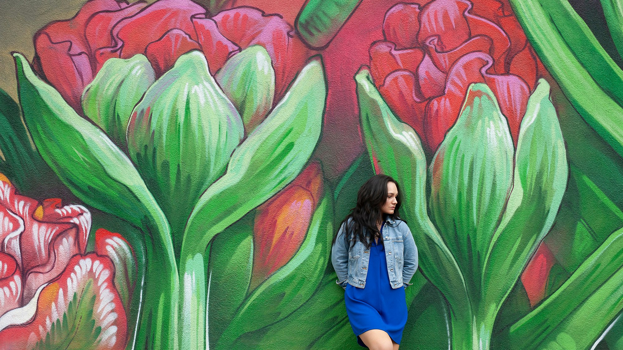 Junge Frau steht neben Graffiti.