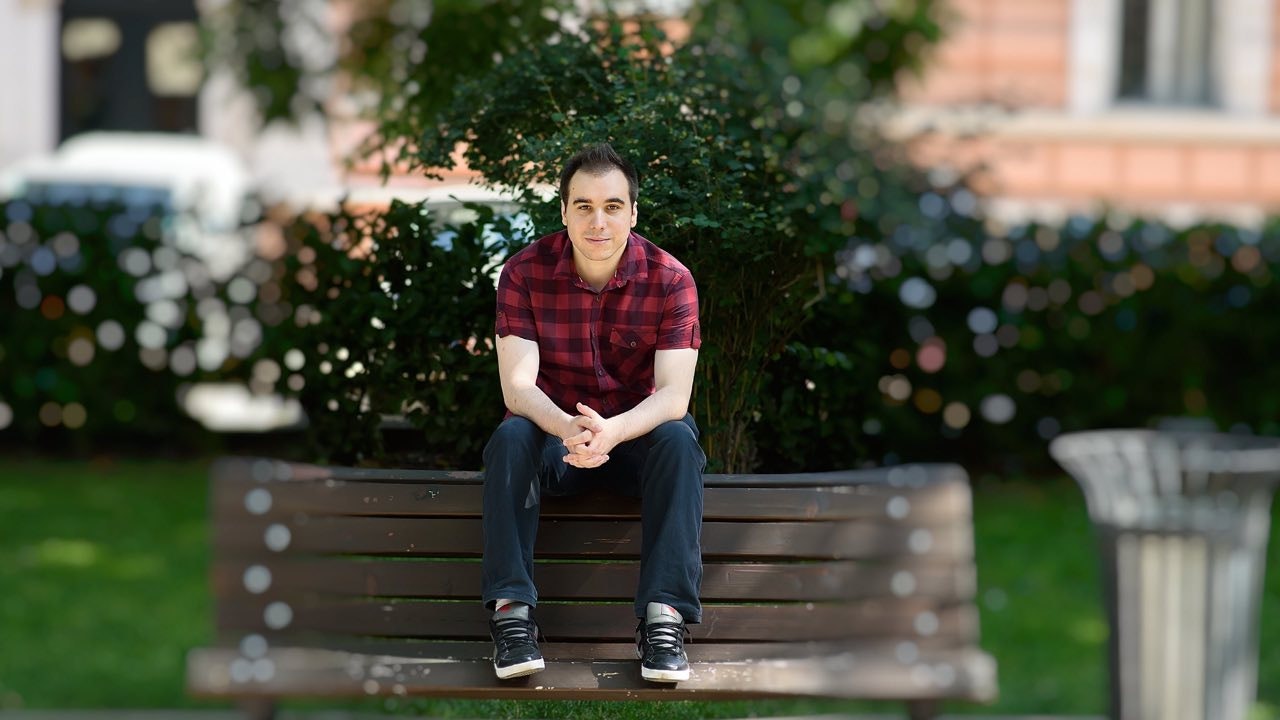 Young man sitting on a bench.