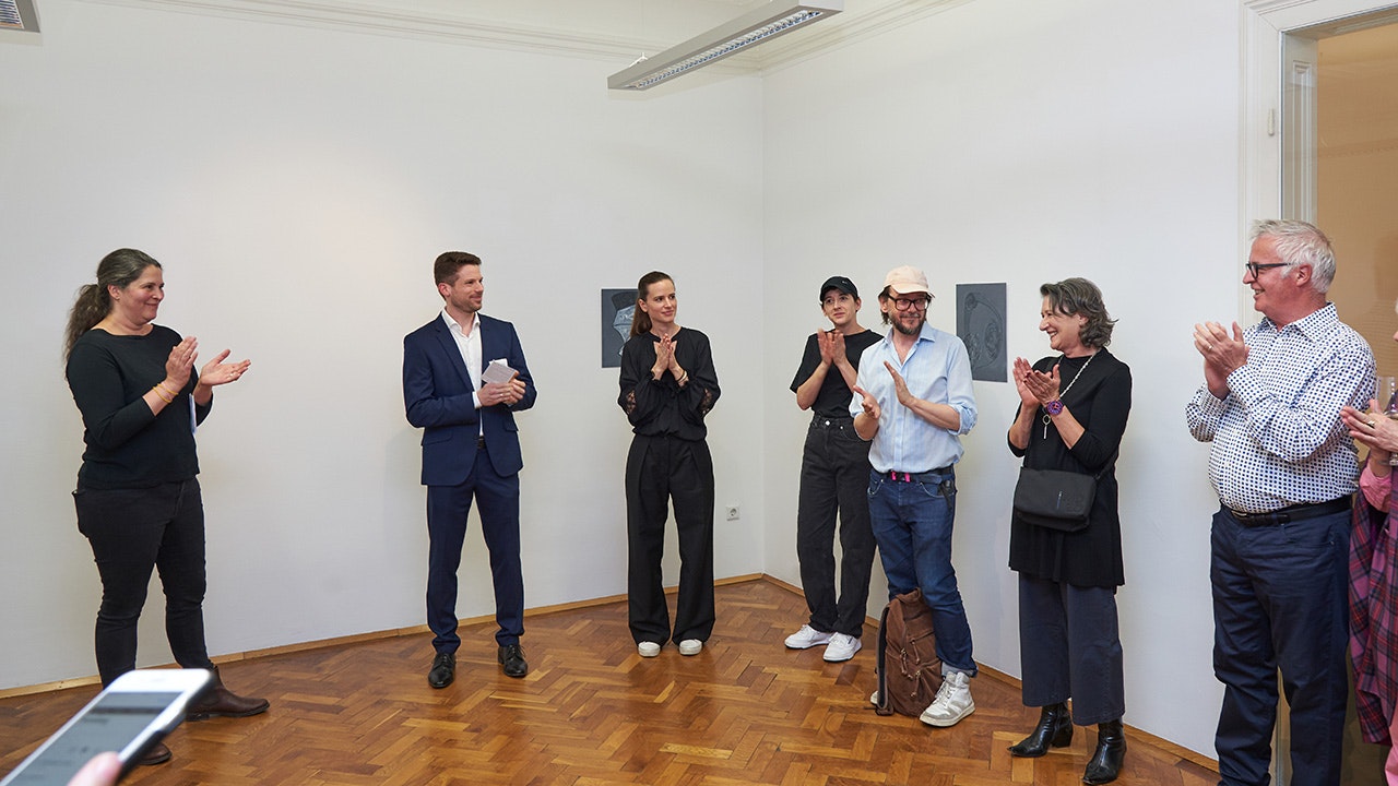 Menschen klatschen freudig in die Hände und lachen sich dabei an.