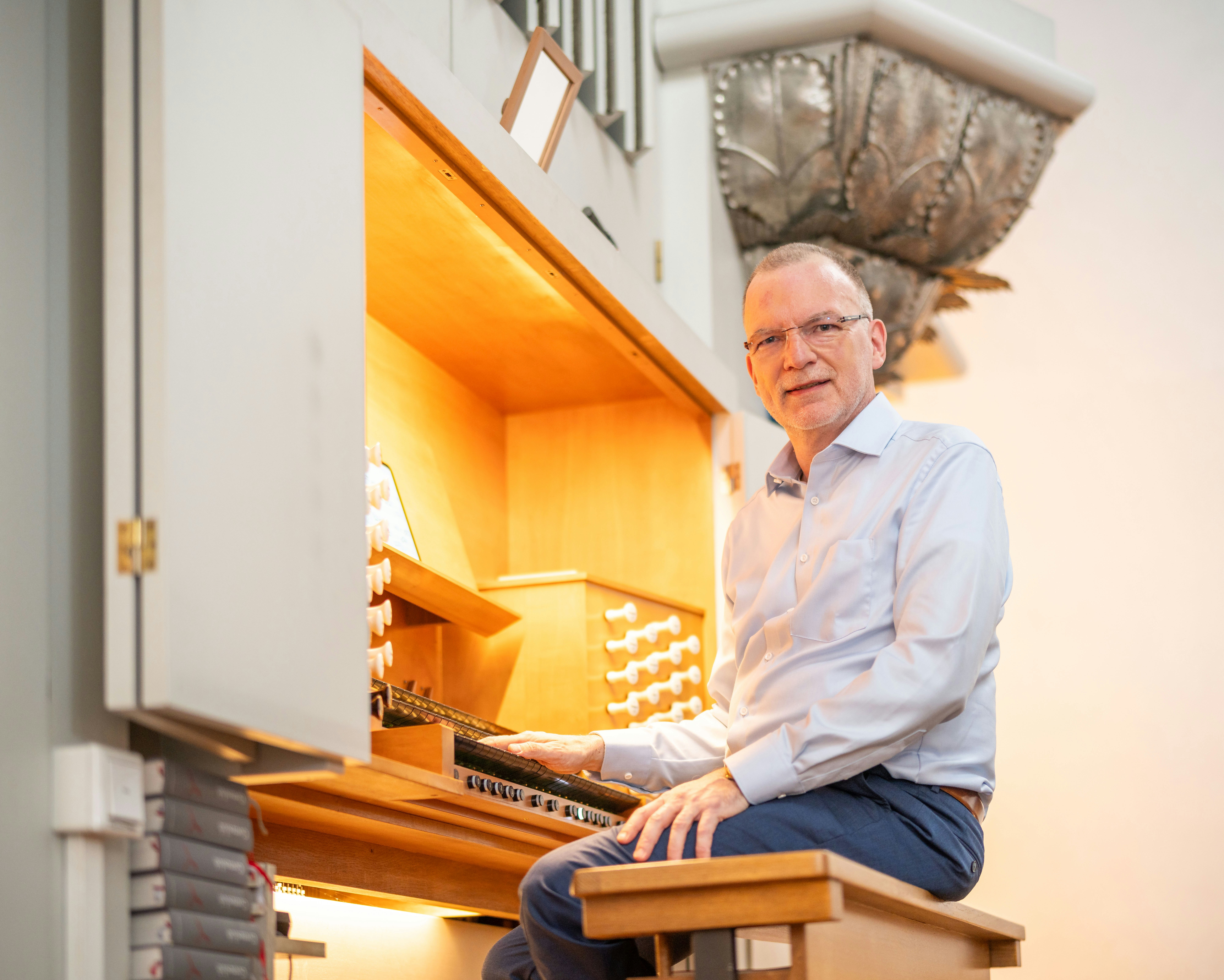 Matthias sits on a church organ bench.