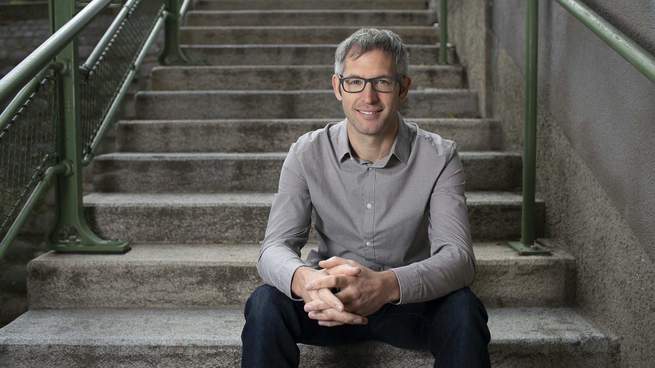 Dietmar is sitting in front of a long staircase.