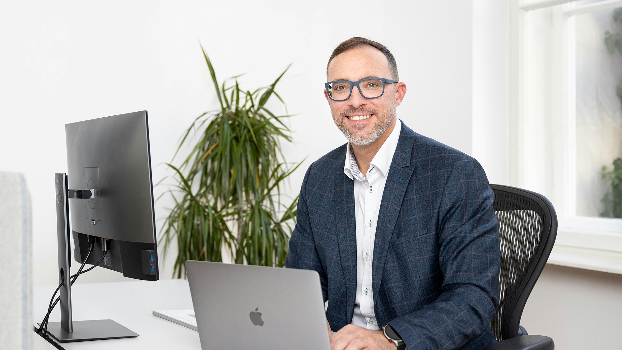 Gernot sits in front of his PC and smiles into the camera.