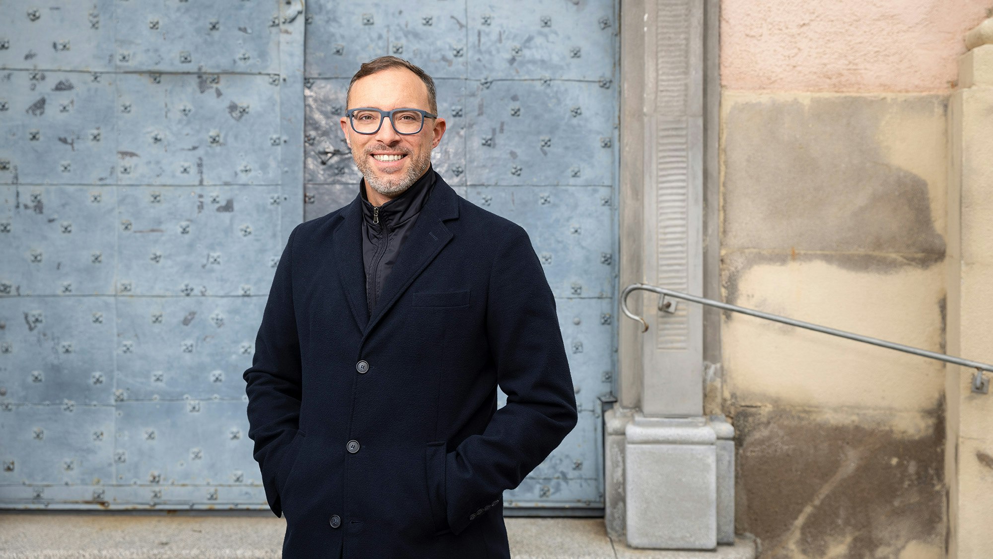 Gernot is standing in front of a historic gate of the church.
