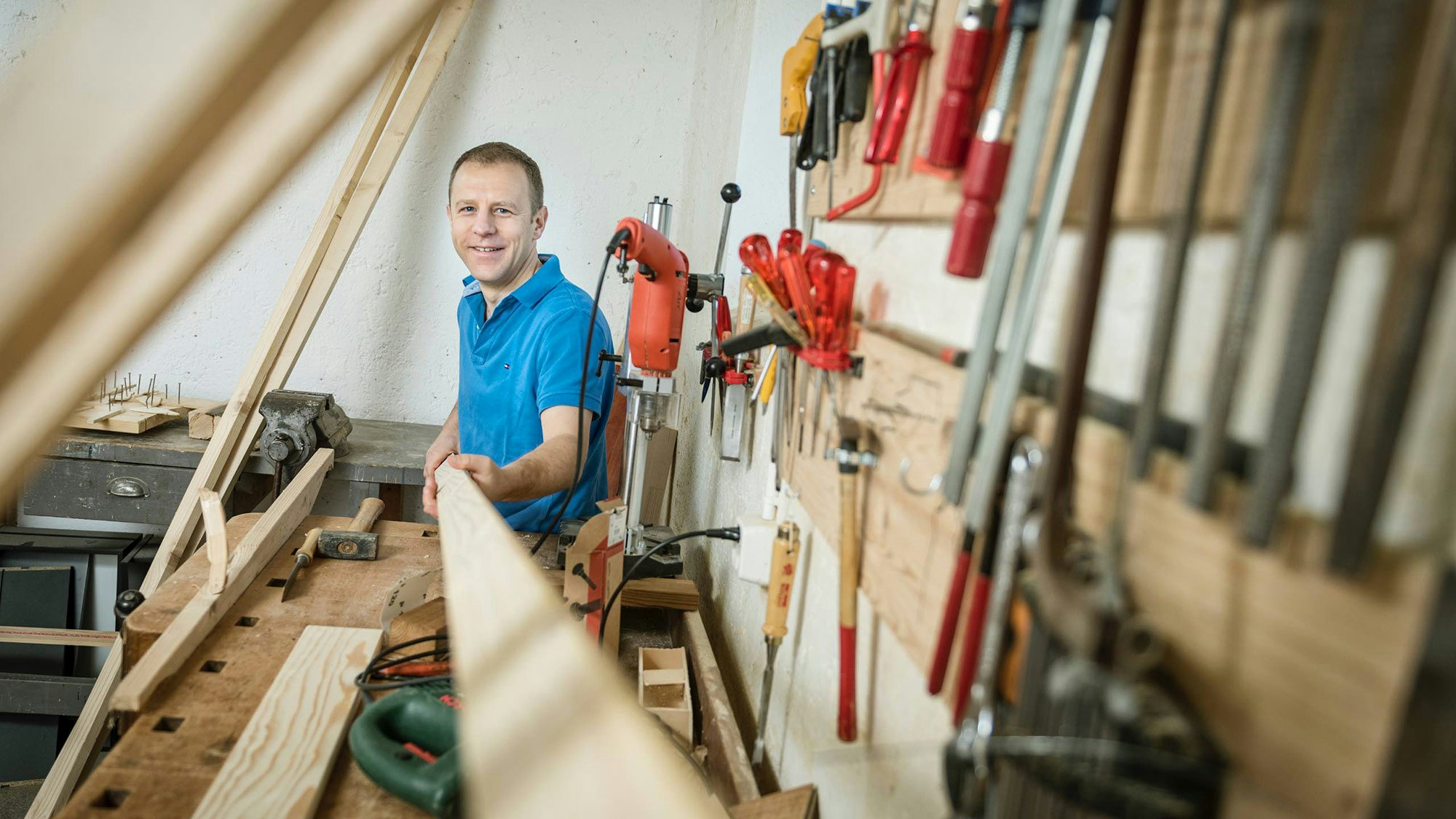 Mann bearbeitet Holz in der Schreinerei.