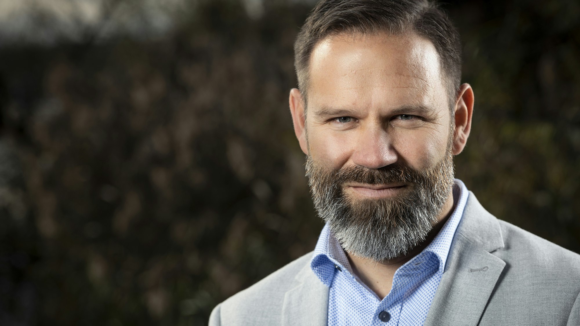 Man with beard looks directly into the camera.