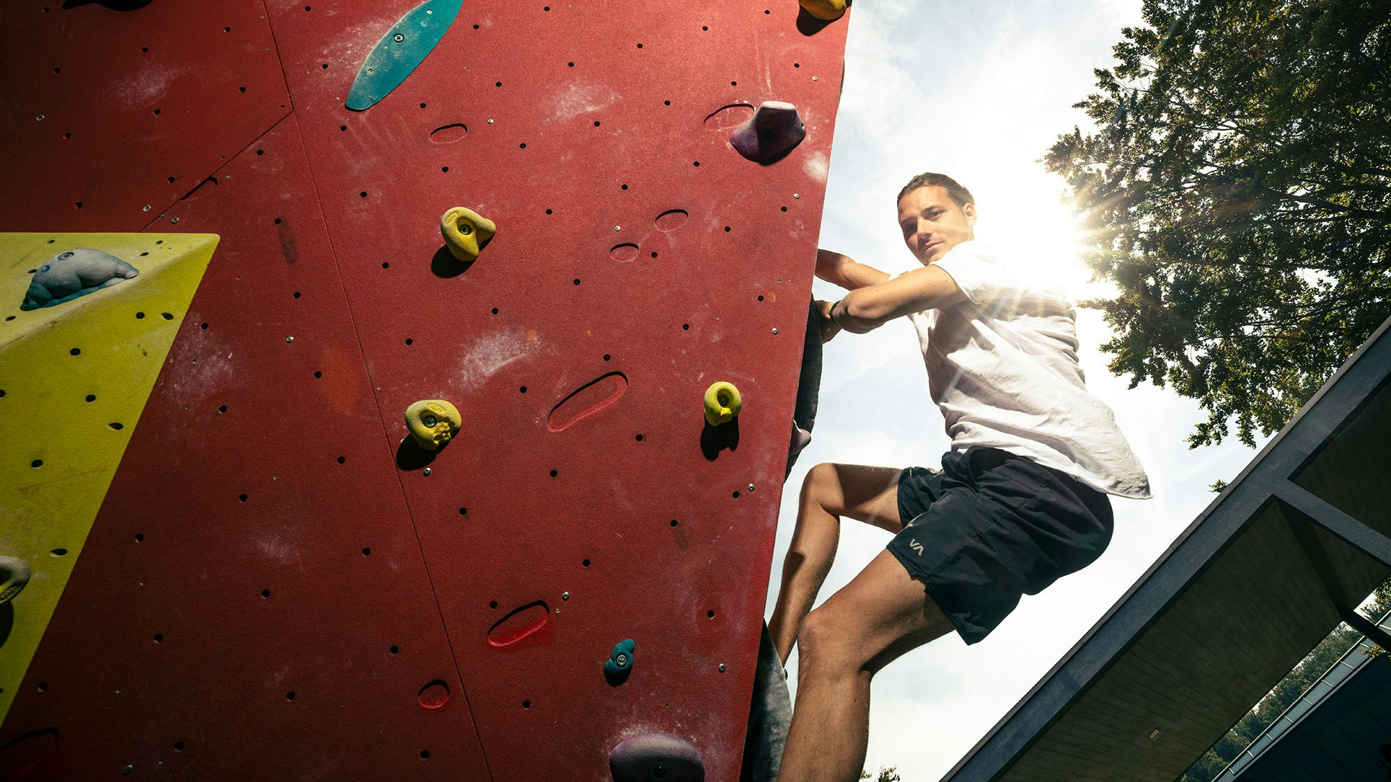 Man on an outdoor climbing wall.