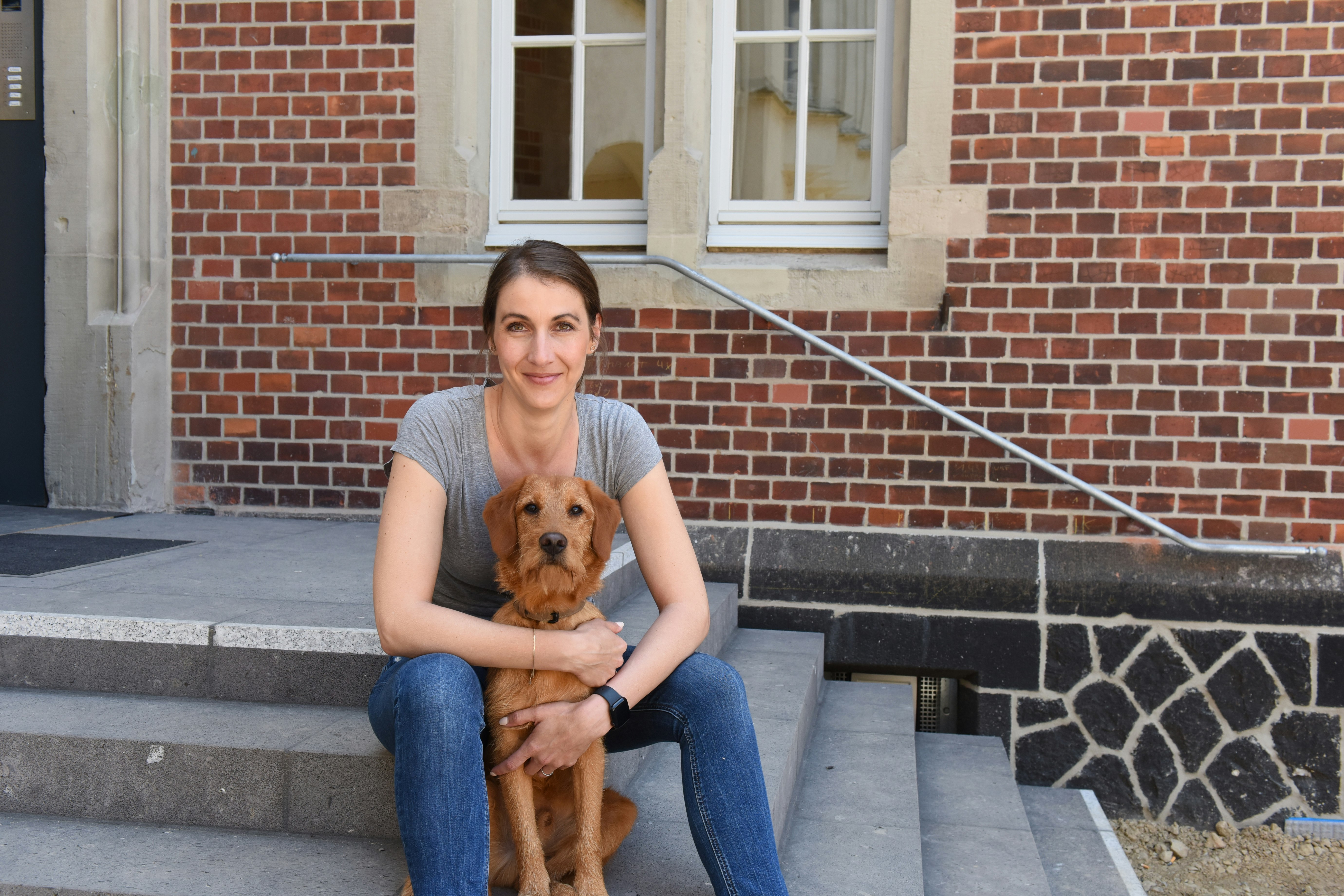 Katrin and Dexter sit on the outside steps to the office.