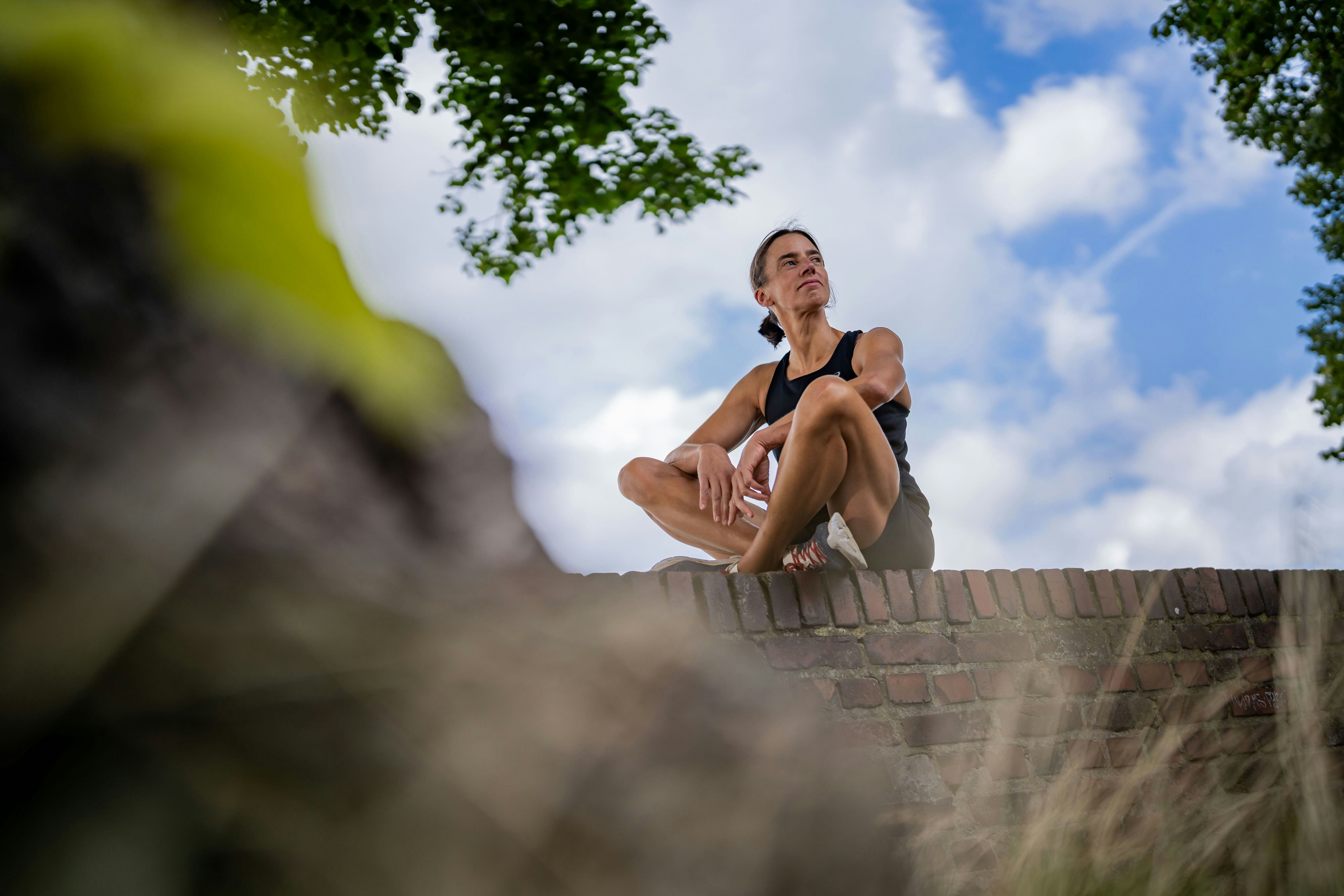 Claudia im Schneidersitz in Laufklamotten