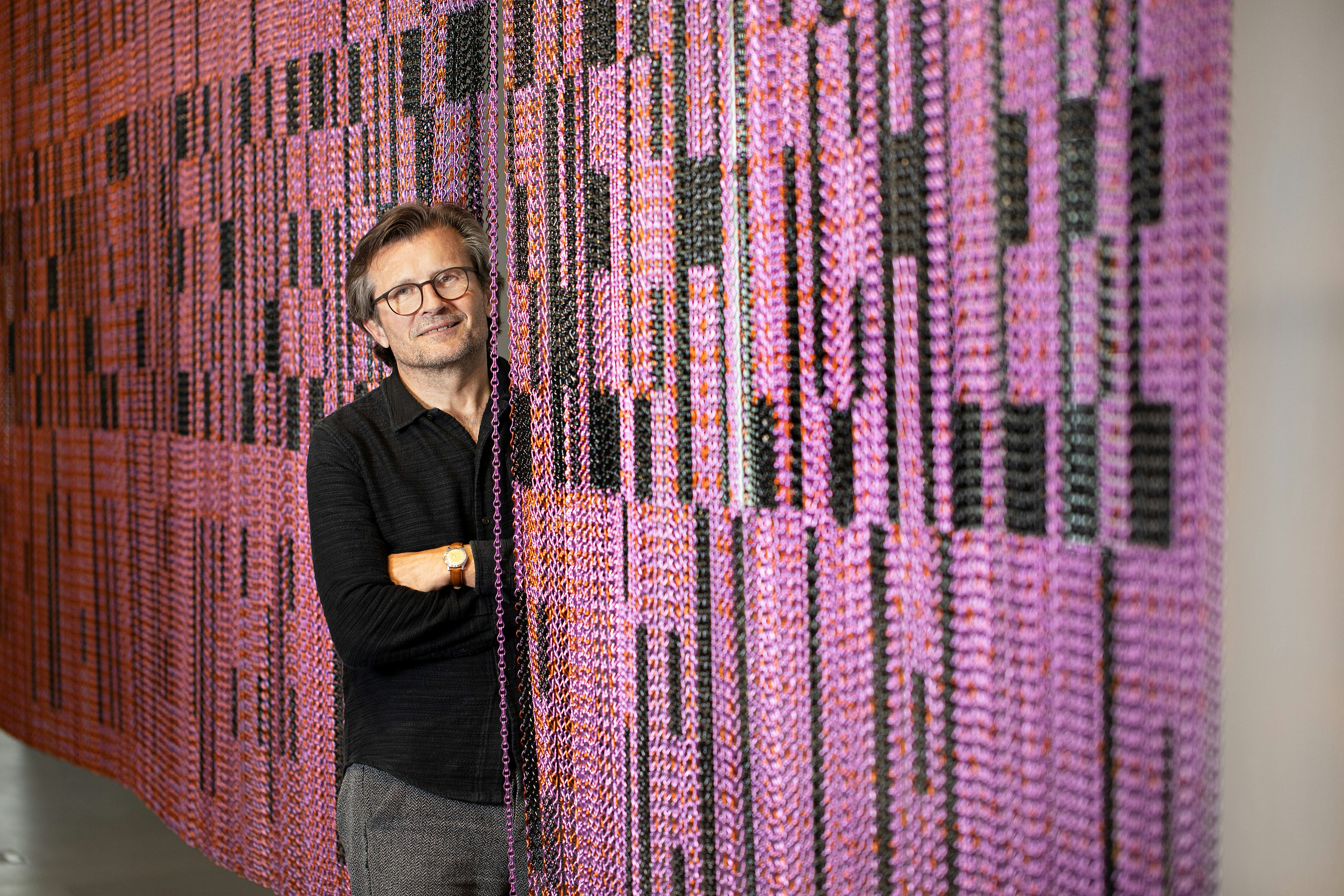 Künstler Marbod Fritsch vor einer pinken und schwarzen Installation