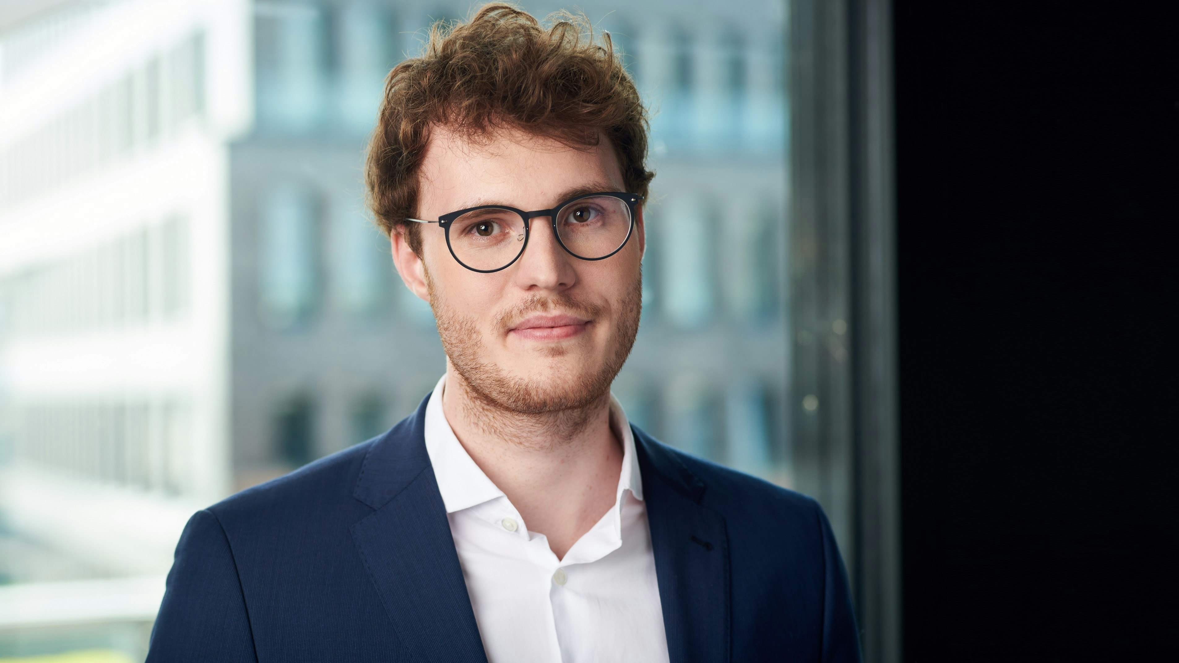 Philip Wintersteiner standing in front of a window and smiling into the camera