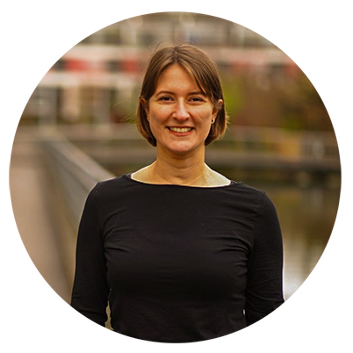 Frau blickt lächelnd in die Kamera