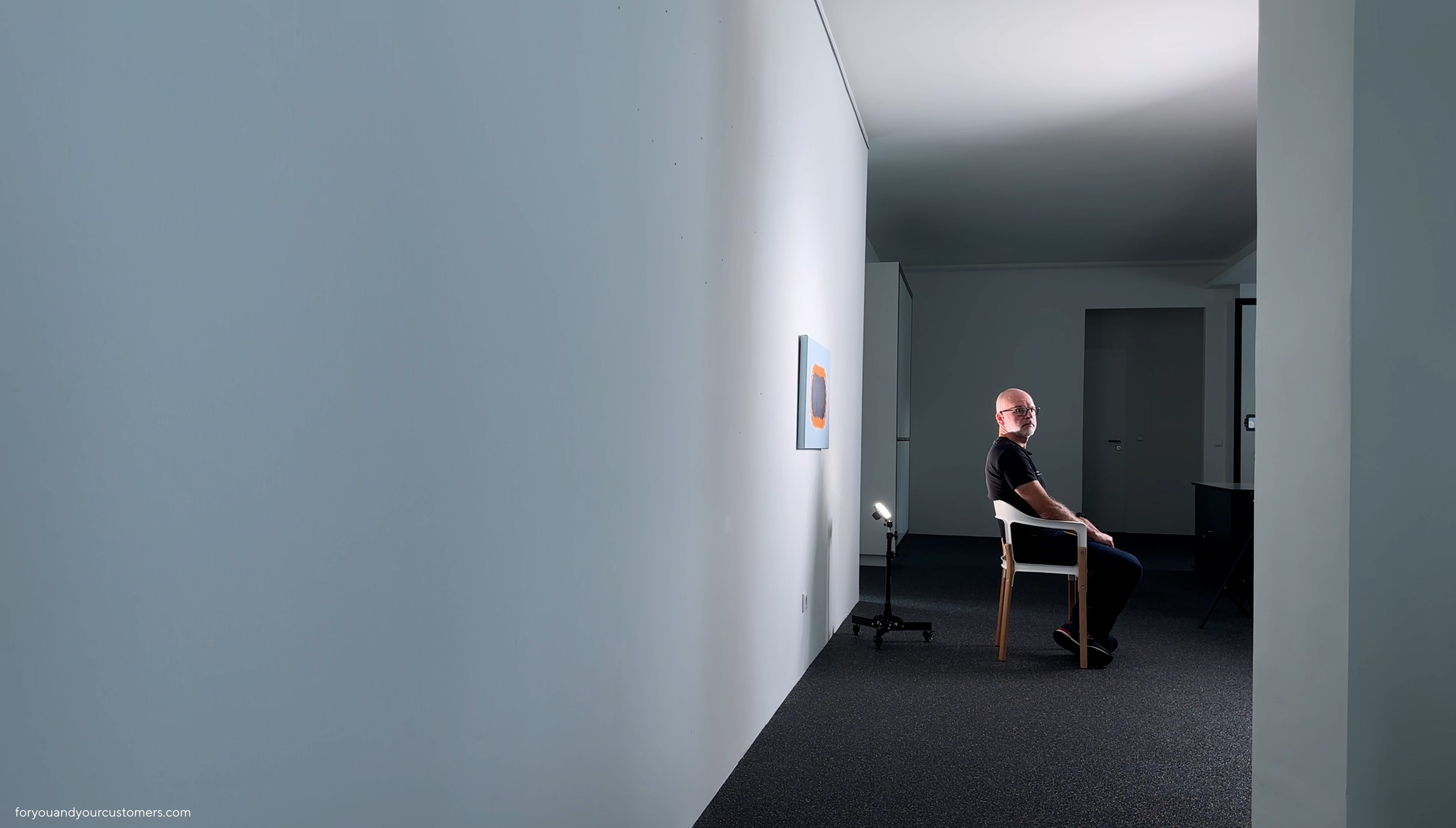 Rainer Fauth sitzt auf einem Stuhl und blickt zur Seite in die Kamera