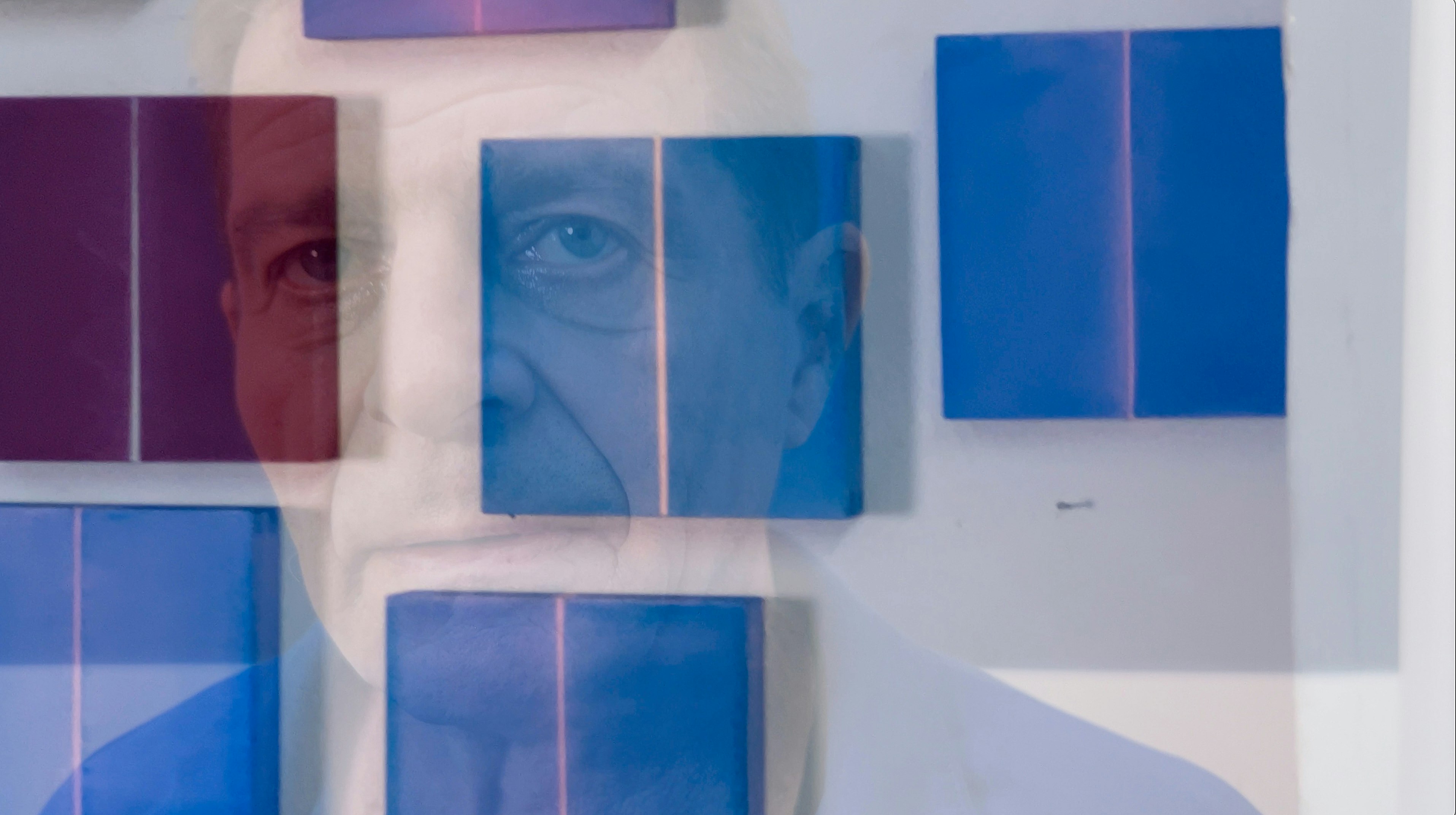 Viele kleinformatige Kunstwerke hängen an einer wand und ein Foto von Christoph Gesing, wo er in die Kamera blickt, scheint leicht durch