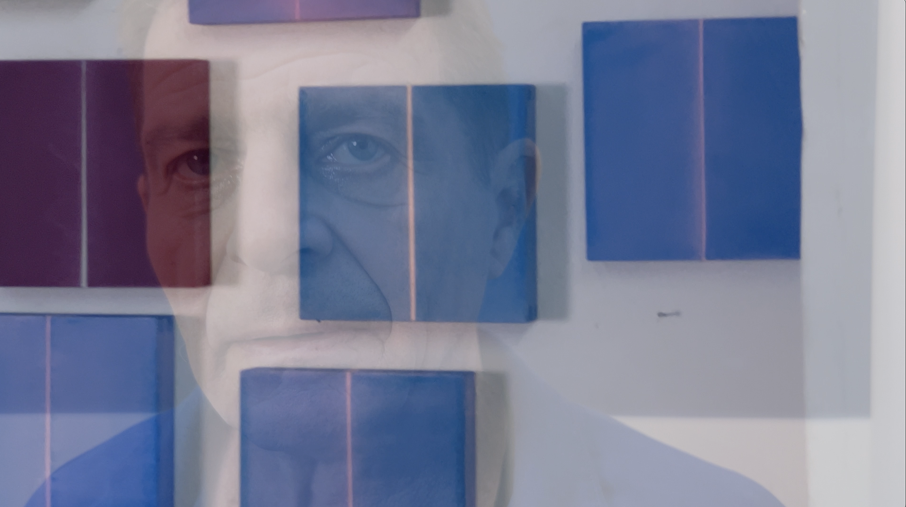 Many small-format artworks hang on a wall, and a photo of Christoph Gesing, where he is looking into the camera, subtly shines through.