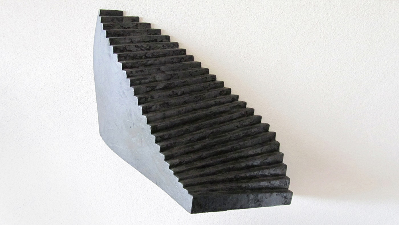 Ein Büroraum voller Kunst, ein schwarzes Gemälde an der einen Wand, eine schwarze 3D-Aktie an der anderen.