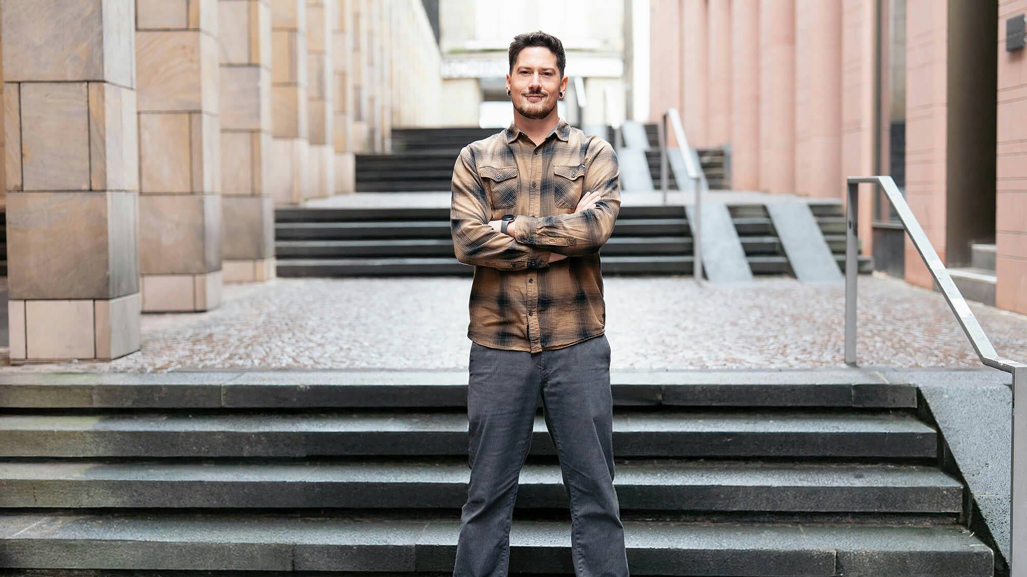 Daniel steht mit verschränkten Armen