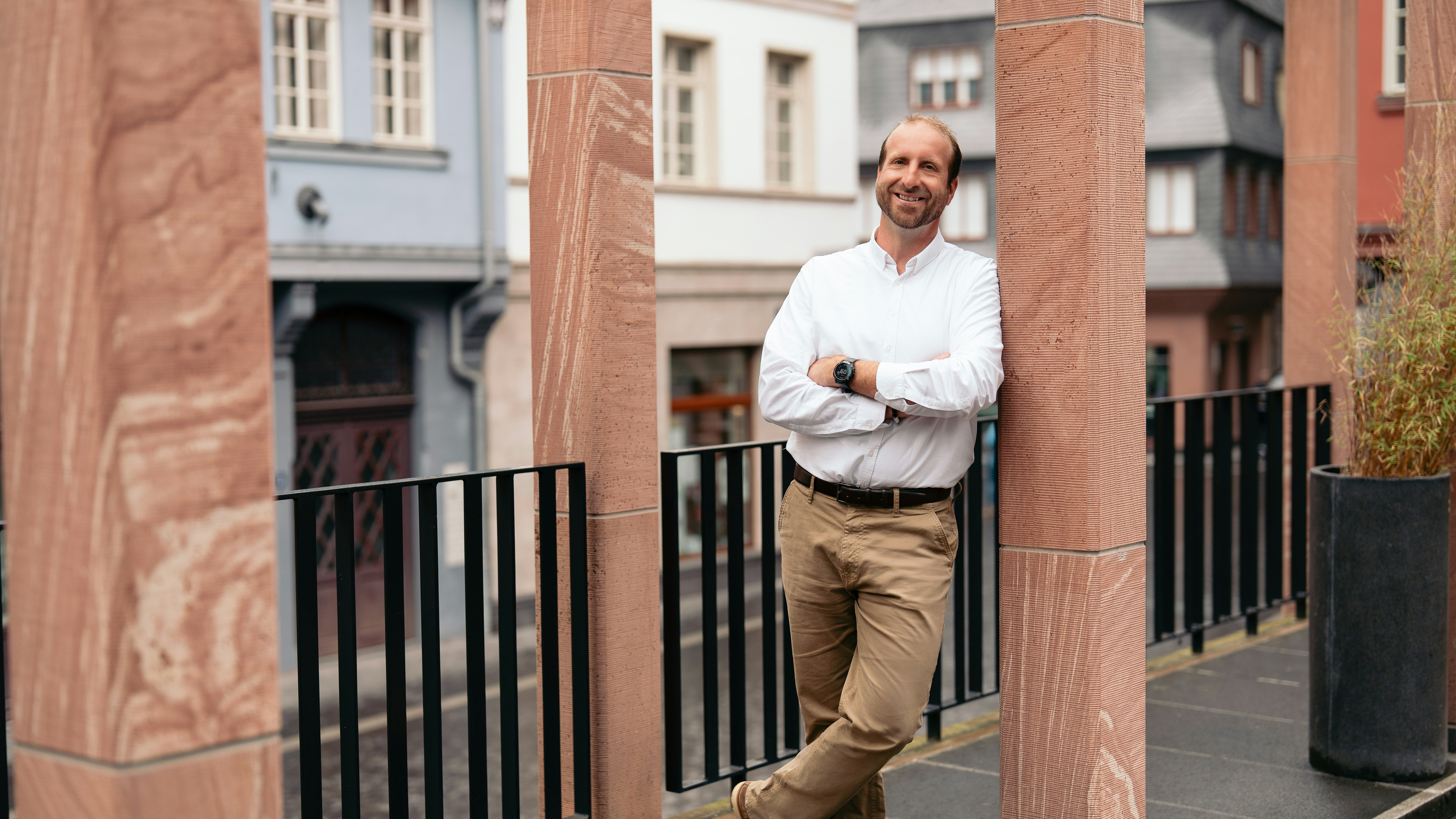 Andreas Gutheil lehnt lächelnd draußen an einer Steinsäule.