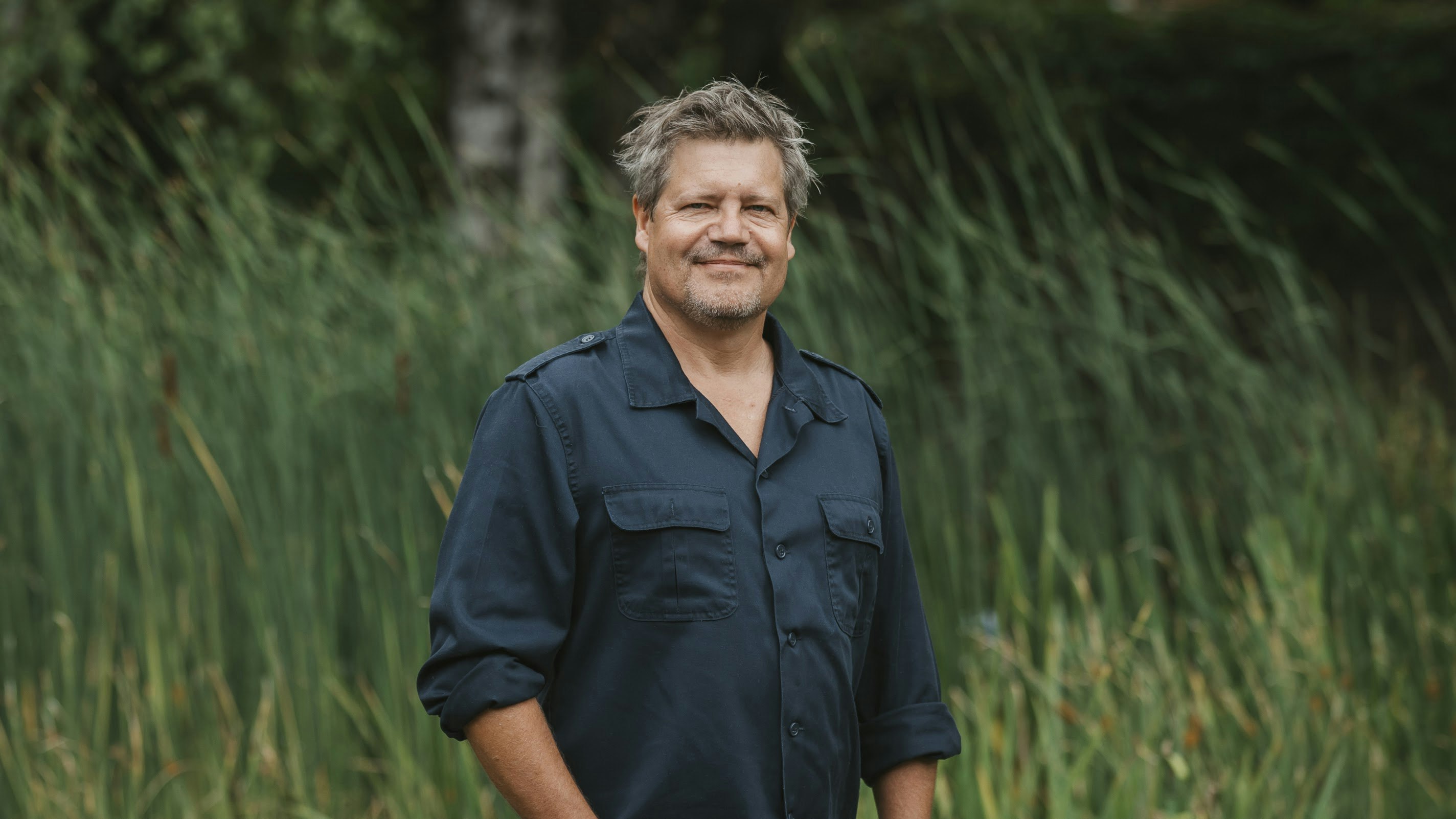 Thomas Jennerwein standing in a meadow in front of trees.