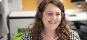 A woman with a head set on smiling