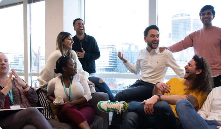 A group photo of people standing, sitting and laughing