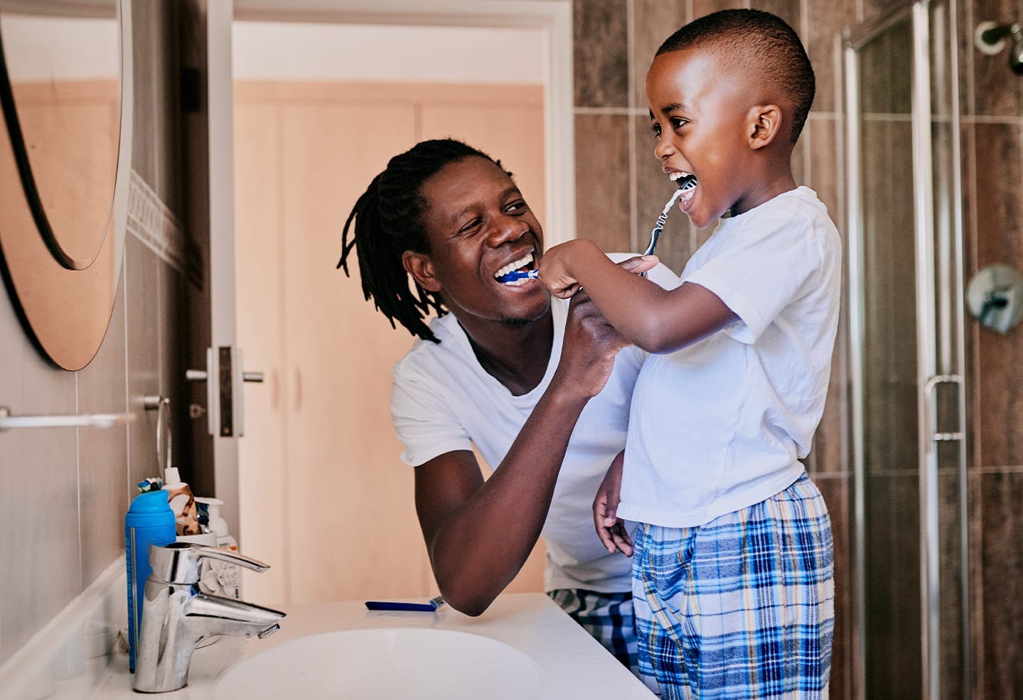 Man brushing his sons teeth