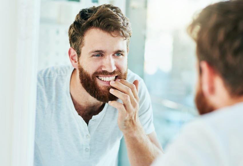 Man looking in the mirror at his teeth