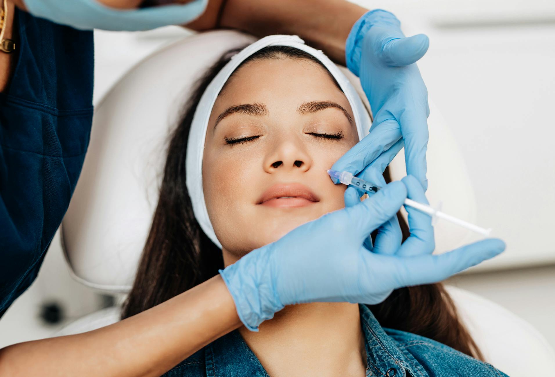 Woman receiving cosmetic injectables to her face