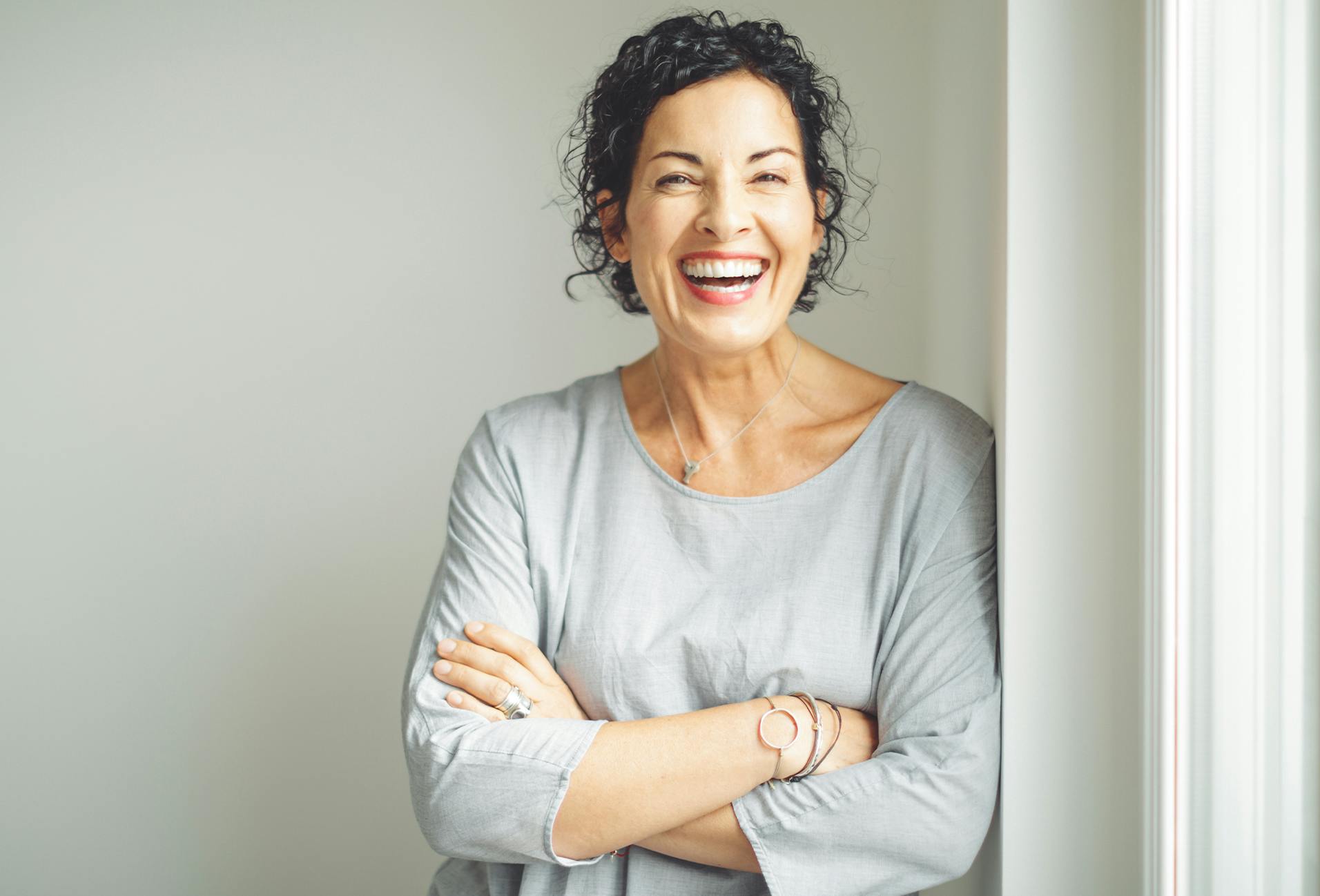 woman laughing with her arms crossed