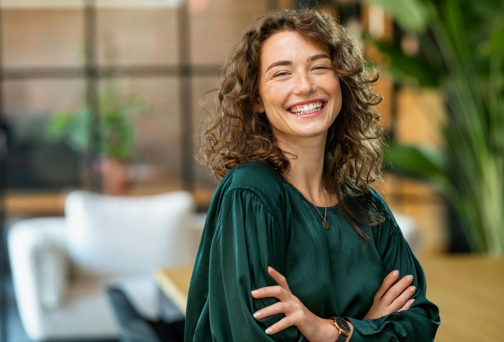 woman with curly hair wearing a green top