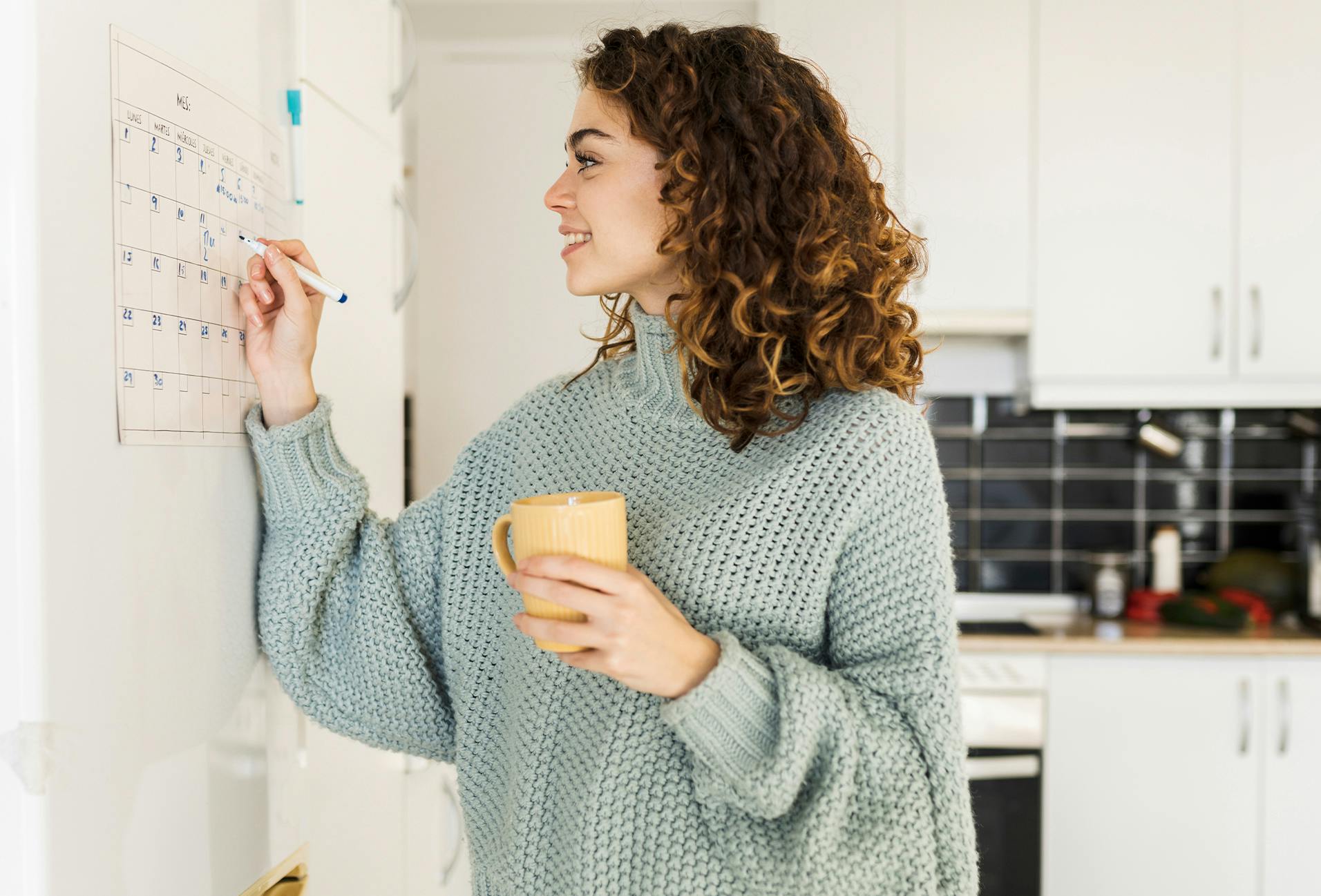 woman writing on a calendar