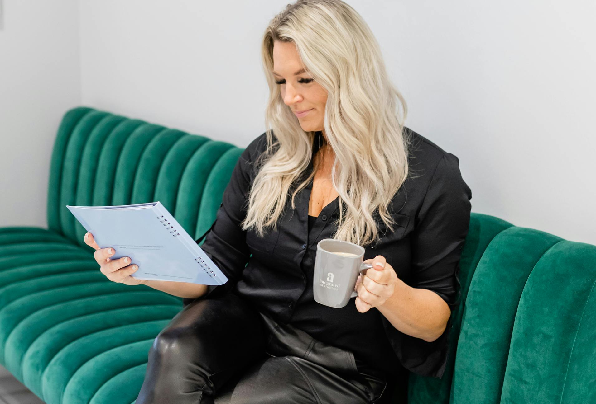 woman looking at a paper while holding a coffee mug