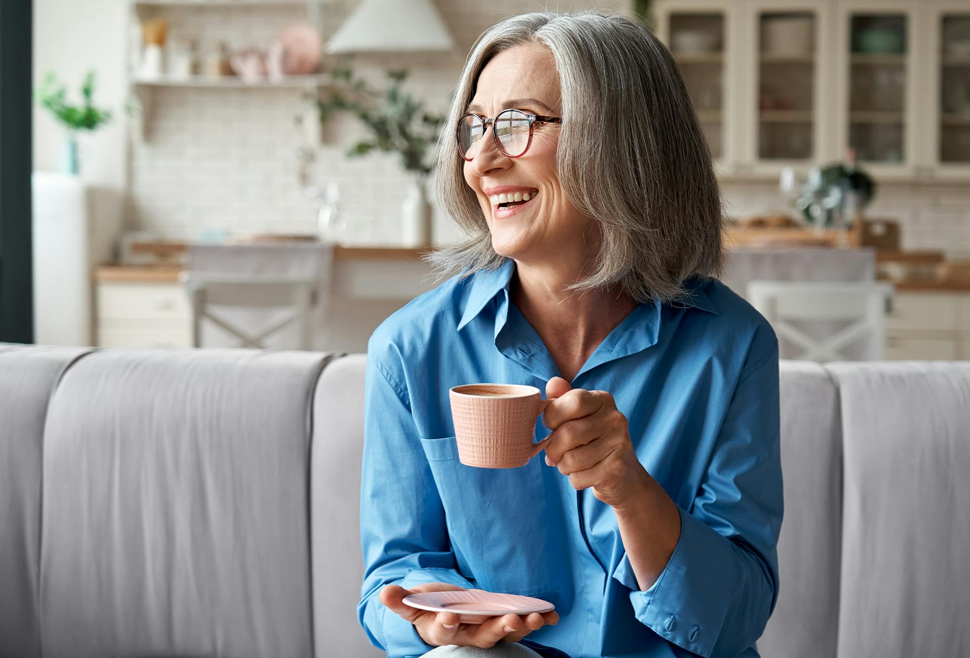 woman in a blue top drinking coffee