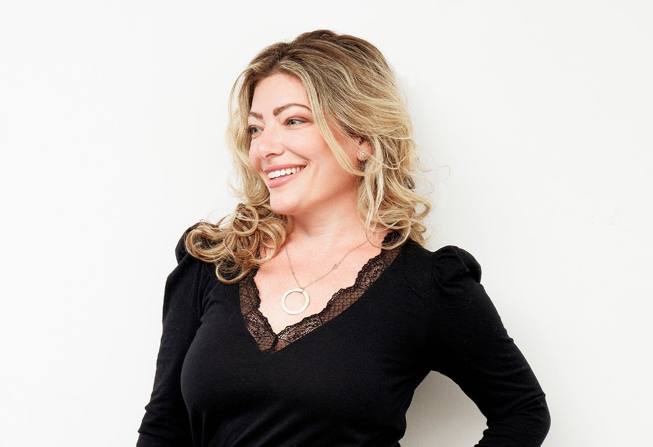 Woman smiling after receiving a mommy makeover