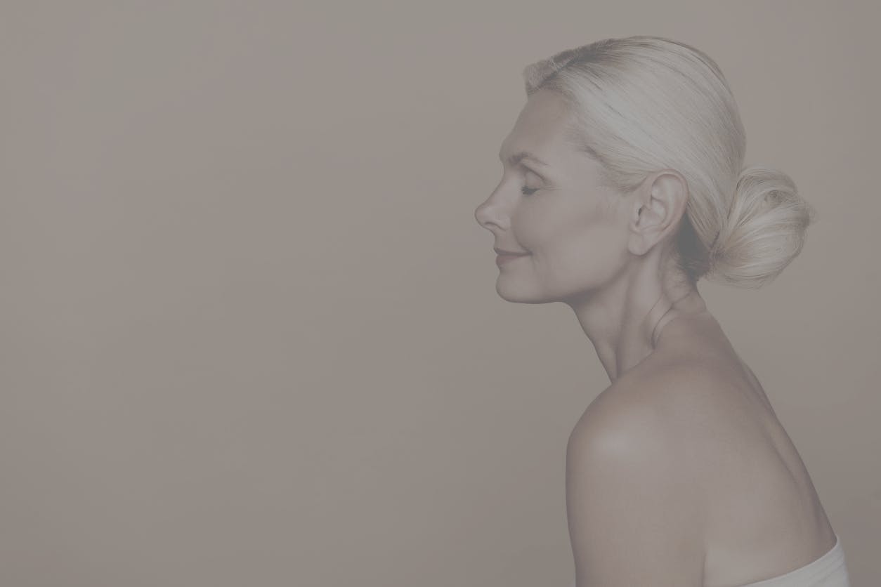 Older woman shows profile in studio shoot to show potential results of a facelift in Long Island with Dr. Tanna