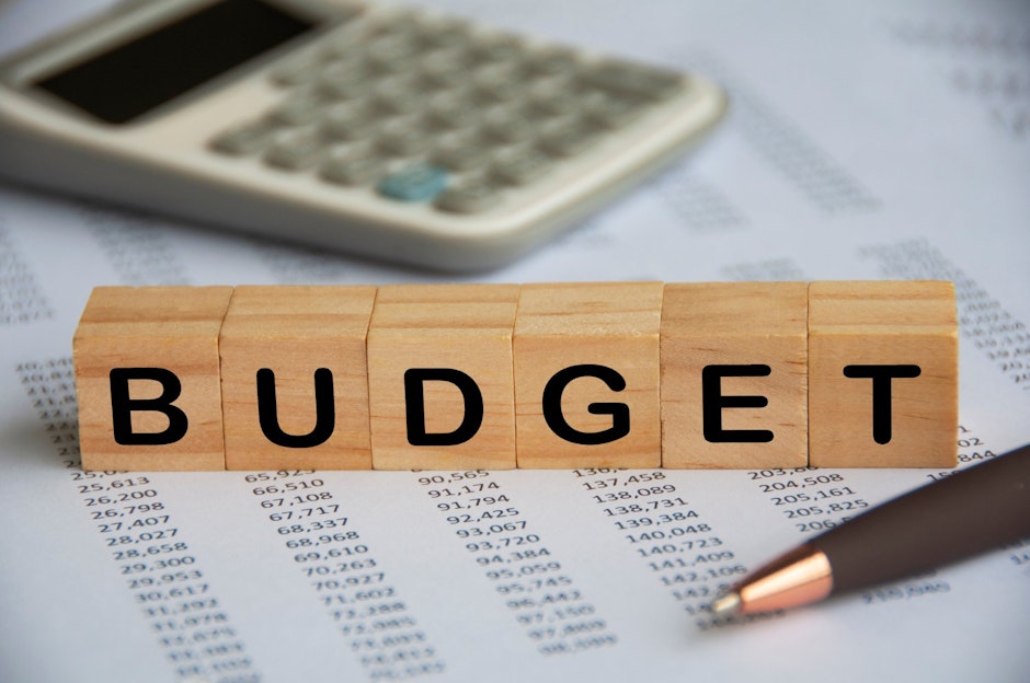 budget spelled on small wooden blocks with calculator and pen