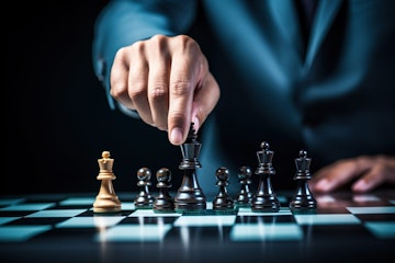 close up of a hand moving a chess piece