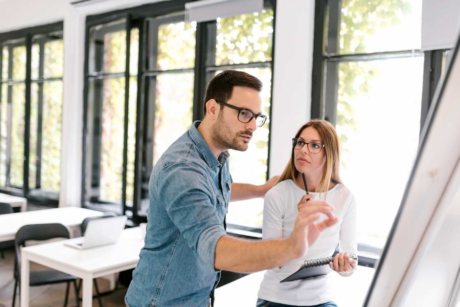 Beautiful business woman and man working with flipchart