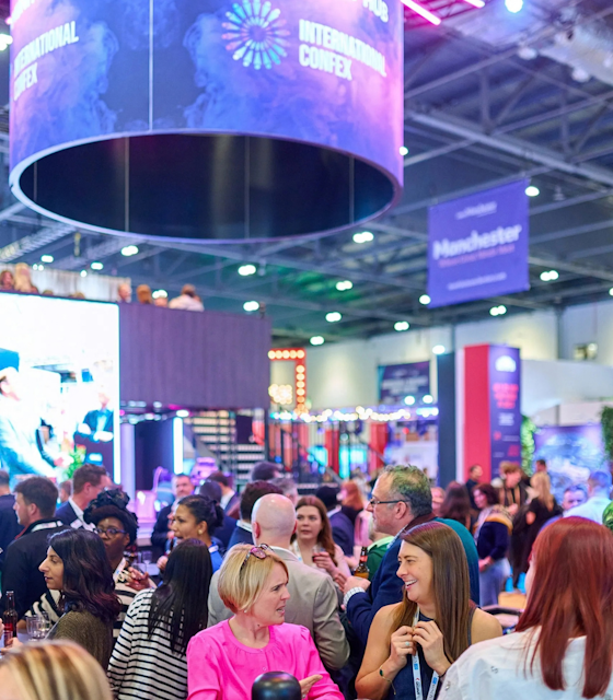 People sat around in a hall with with International Confex branding in the background