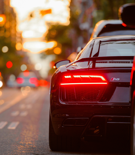 Stock Photo of a sports car rear break light on a road.