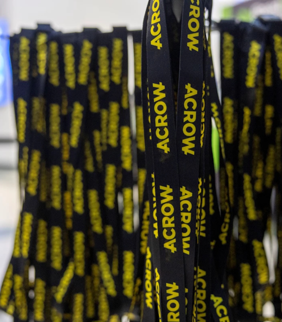 A rack of black hanging lanyards with ACROW written in bright yellow down them.