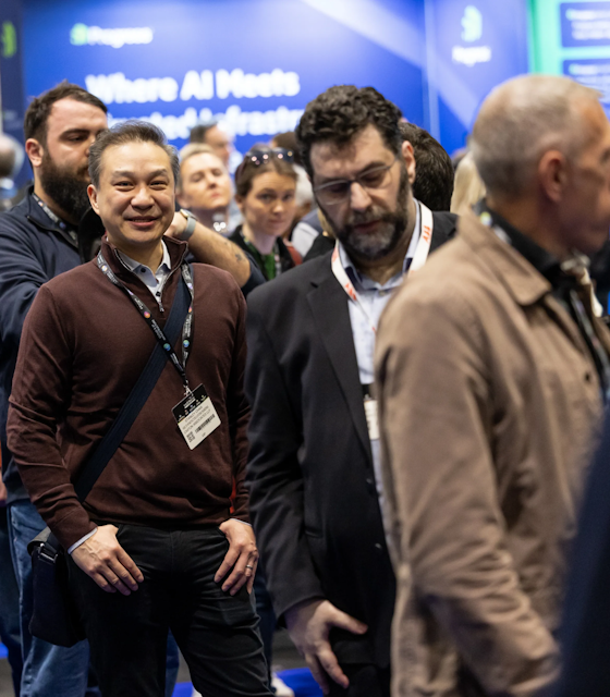A line of professional men with lanyards stood waiting at the Cloud AI Infrastructure Show.