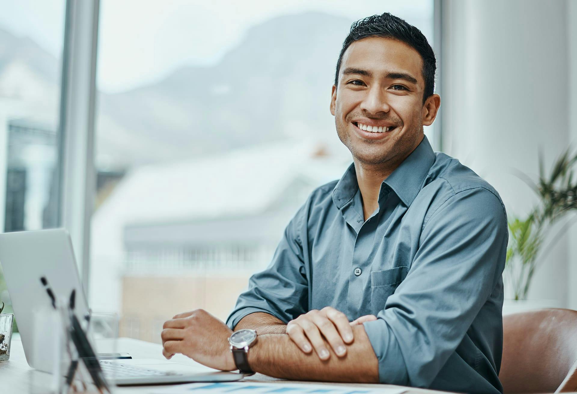 Man sitting at a desk, smiling