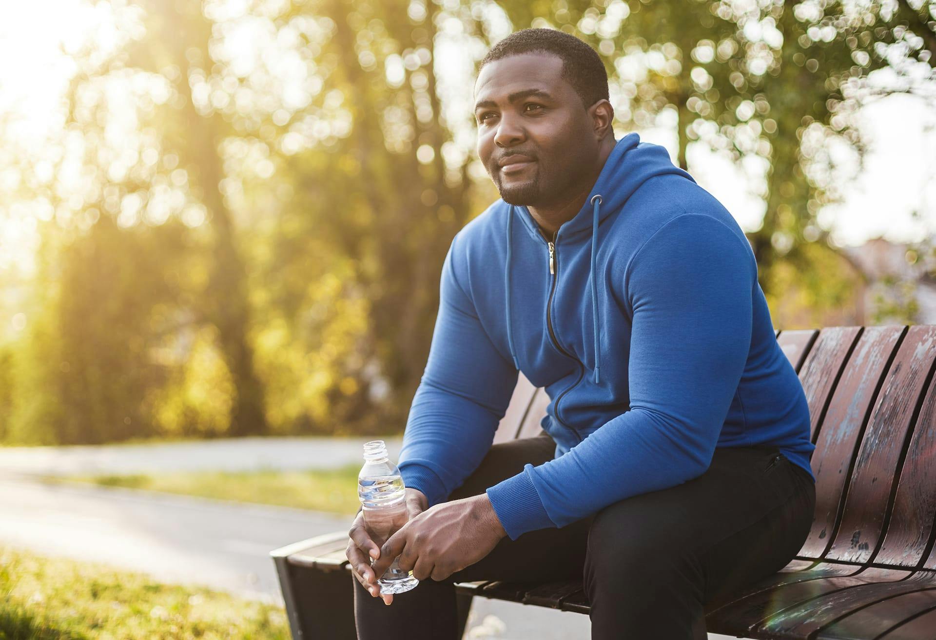 Man in a blue sweater sitting on a bench