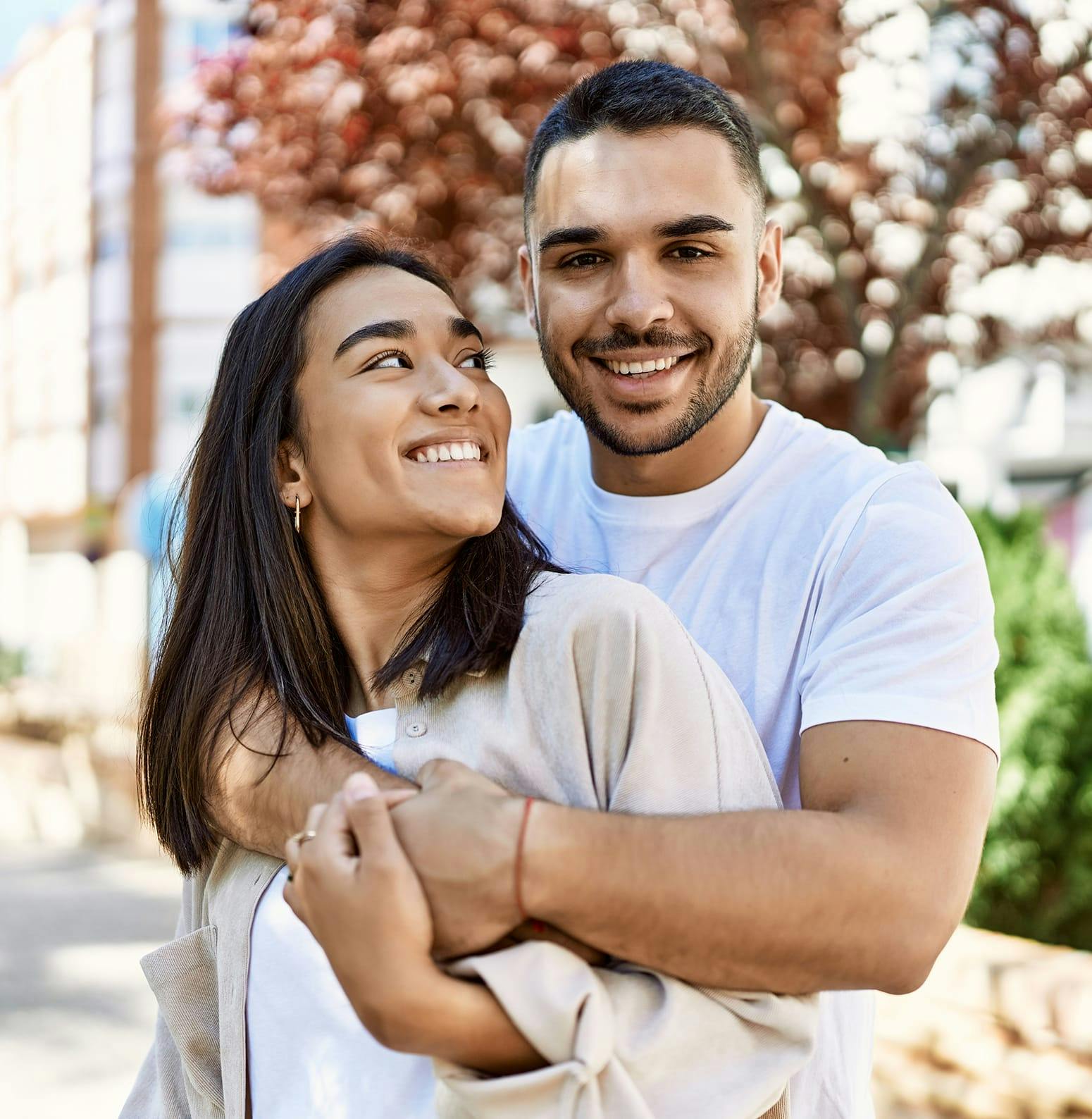 Man wrapping his arms around a woman