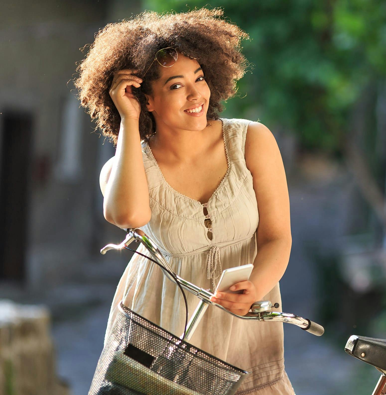 Woman with a bike in one hand and her hair in the other