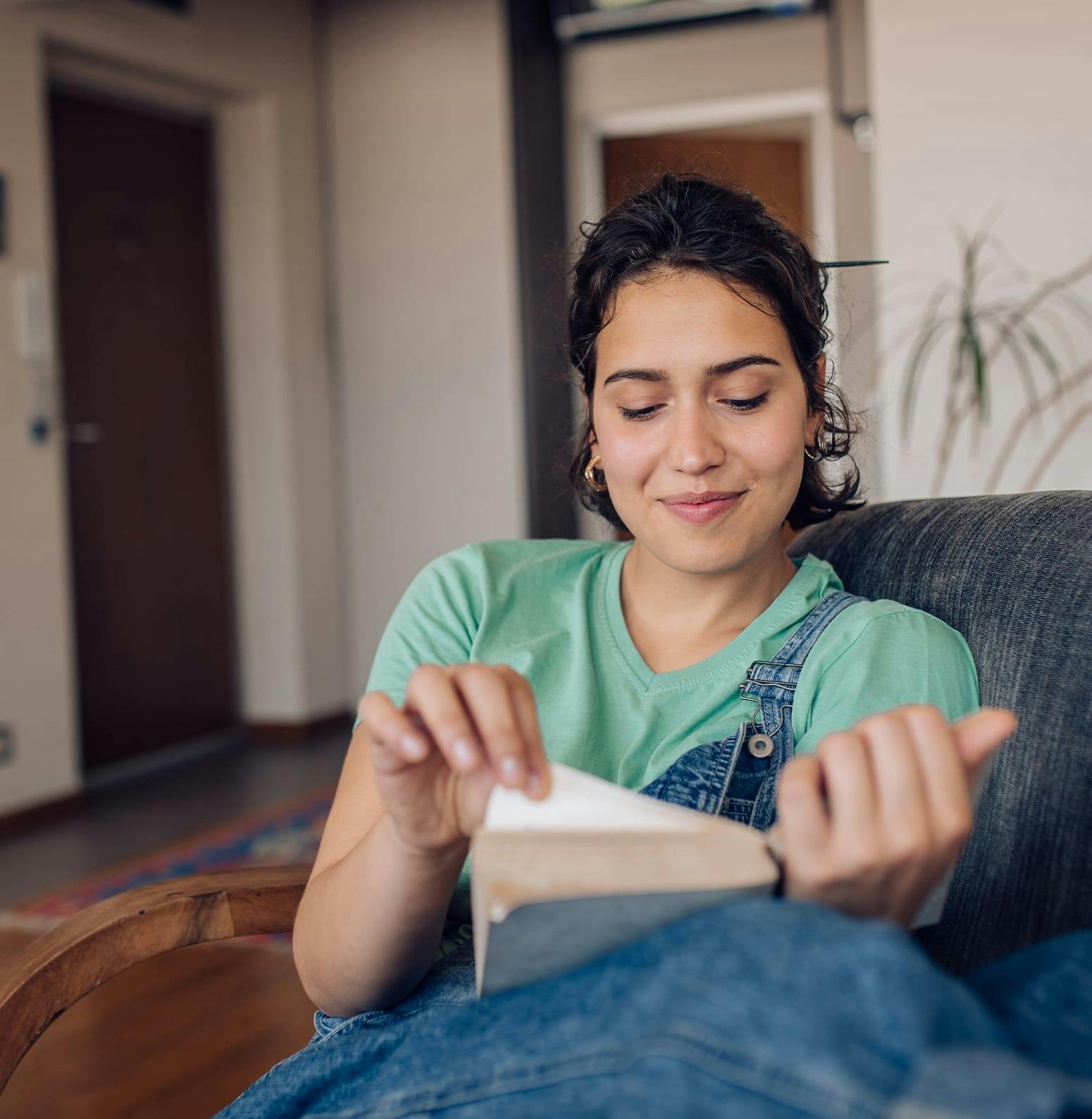 Woman sitting on a couch reading a book