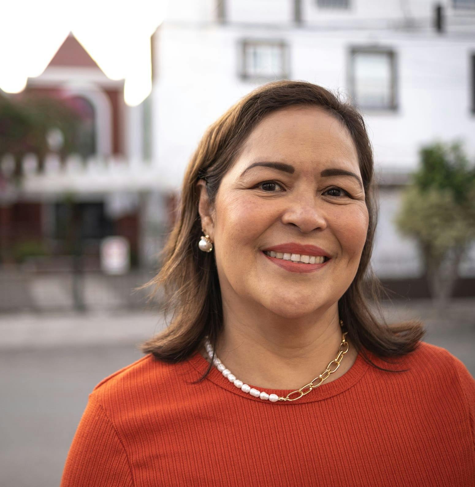 Woman standing on the sidewalk, smiling