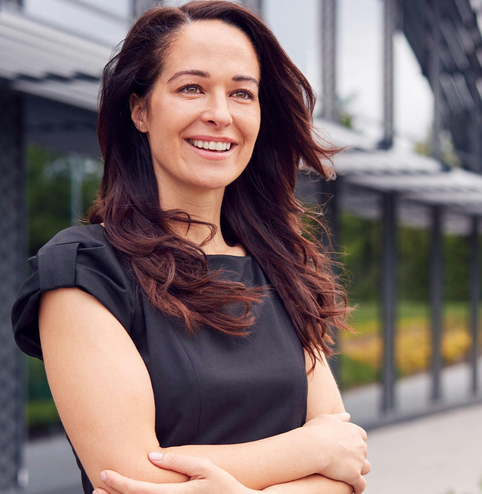 Woman in a black shirt standing on the sidewalk